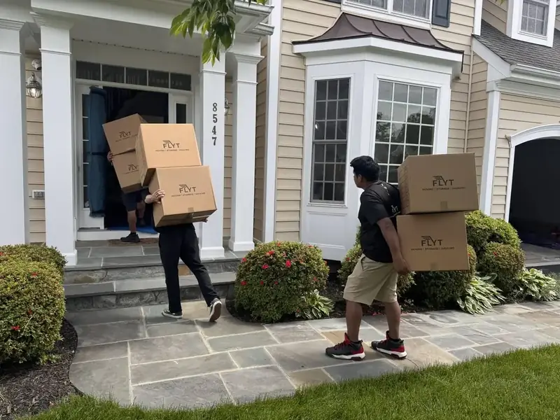 FLYT Moving crew carrying boxes into a new mid-rise apartment in the Hyattsville, MD Arts District