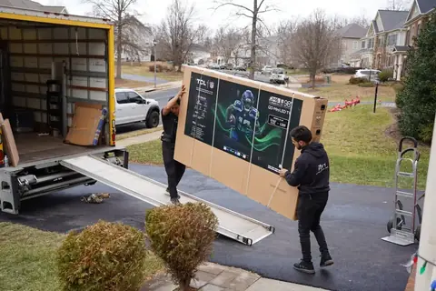 FLYT Moving crew carrying furniture from a historic Federal rowhouse on a cobblestone Georgetown street
